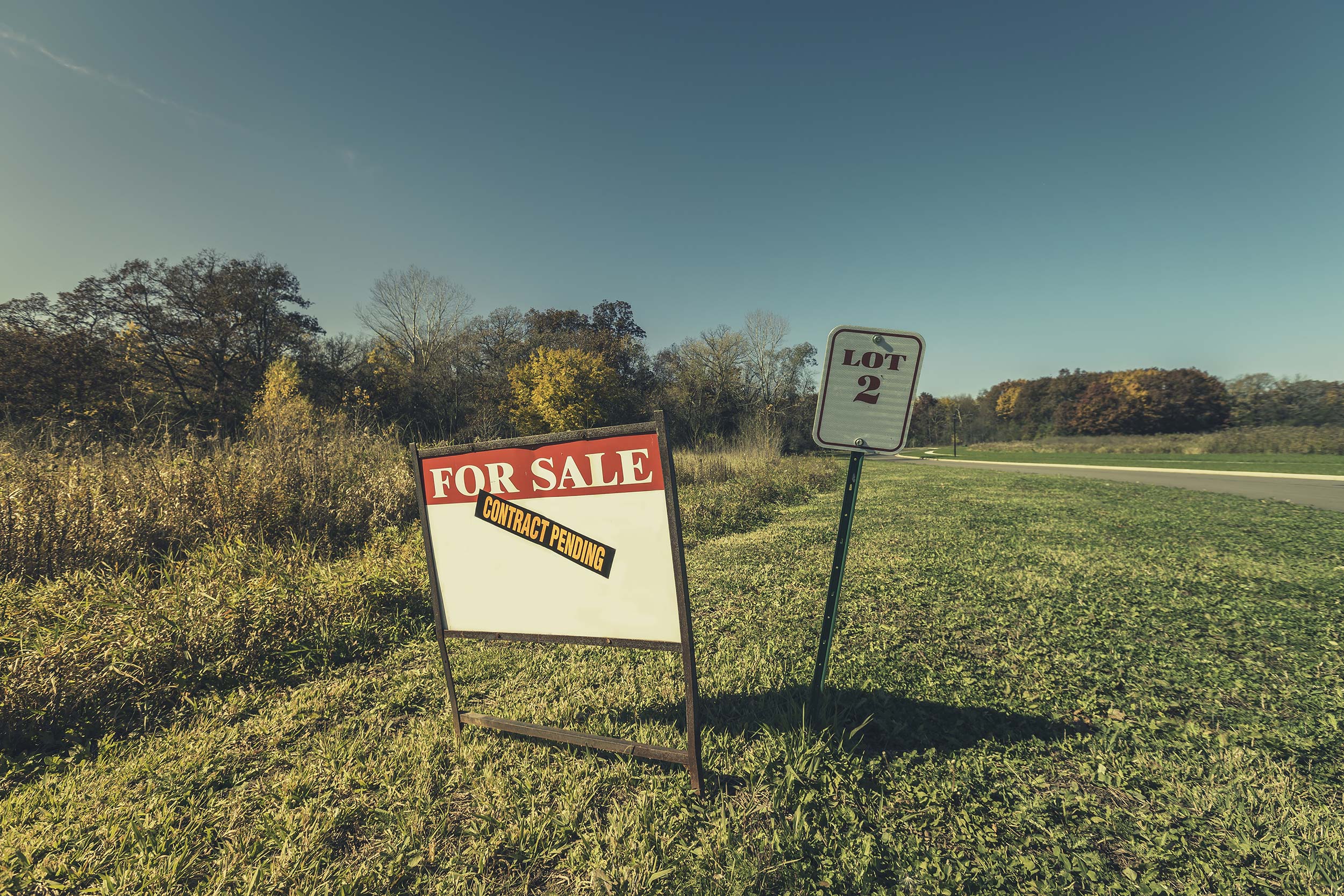 empty lot with lot for sale sign